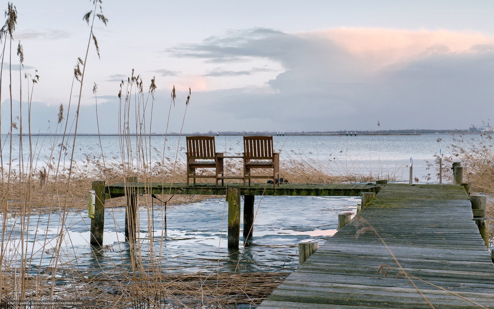 Two chairs on a dock at dusk