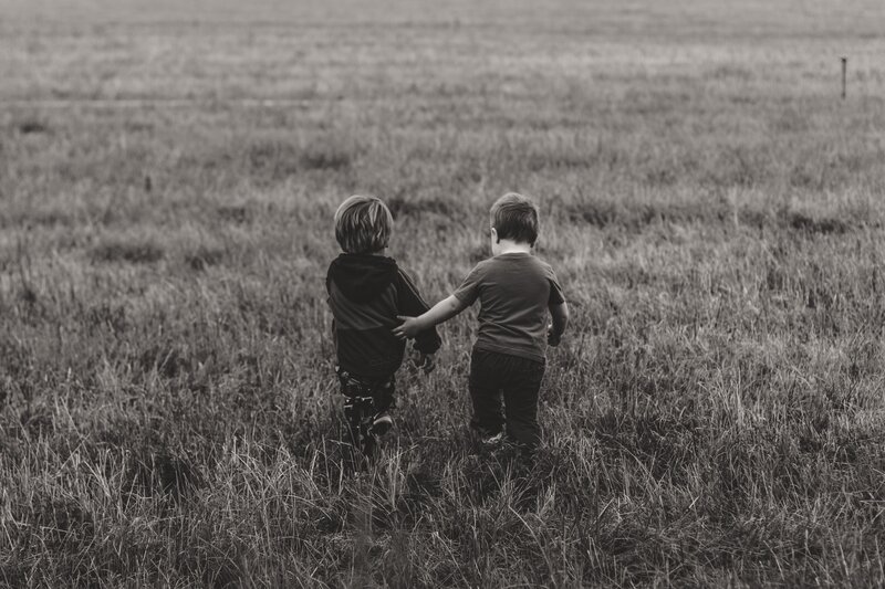 two children walking in a field