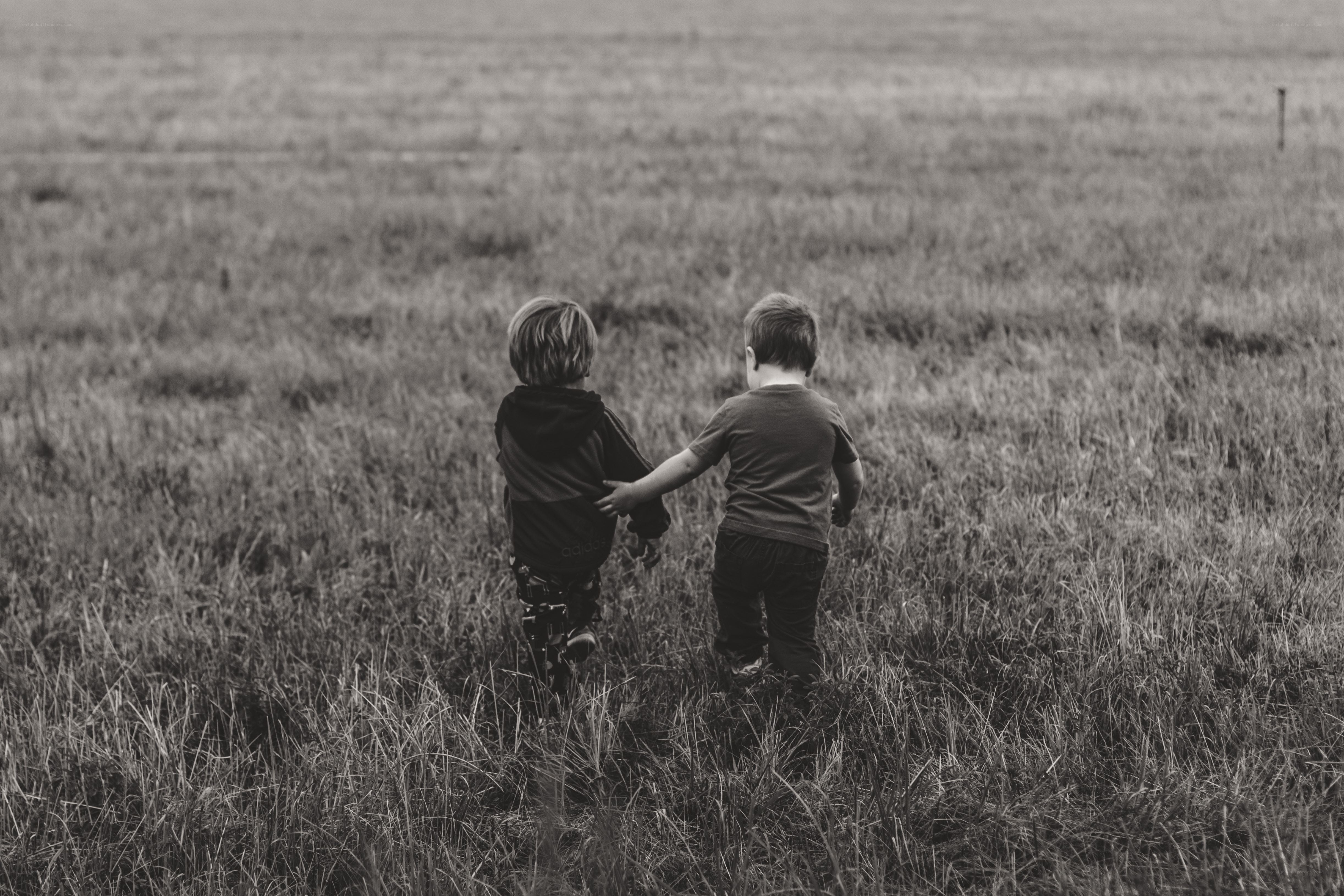 two children walking in a field