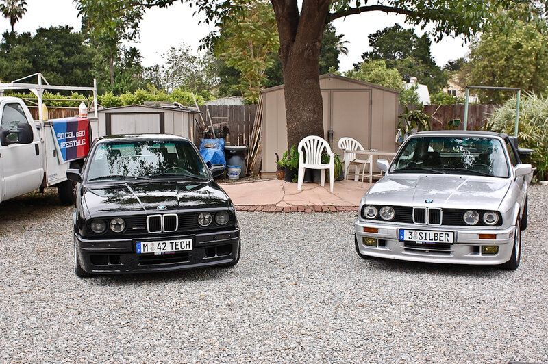 Two classic BMW cars in a driveway