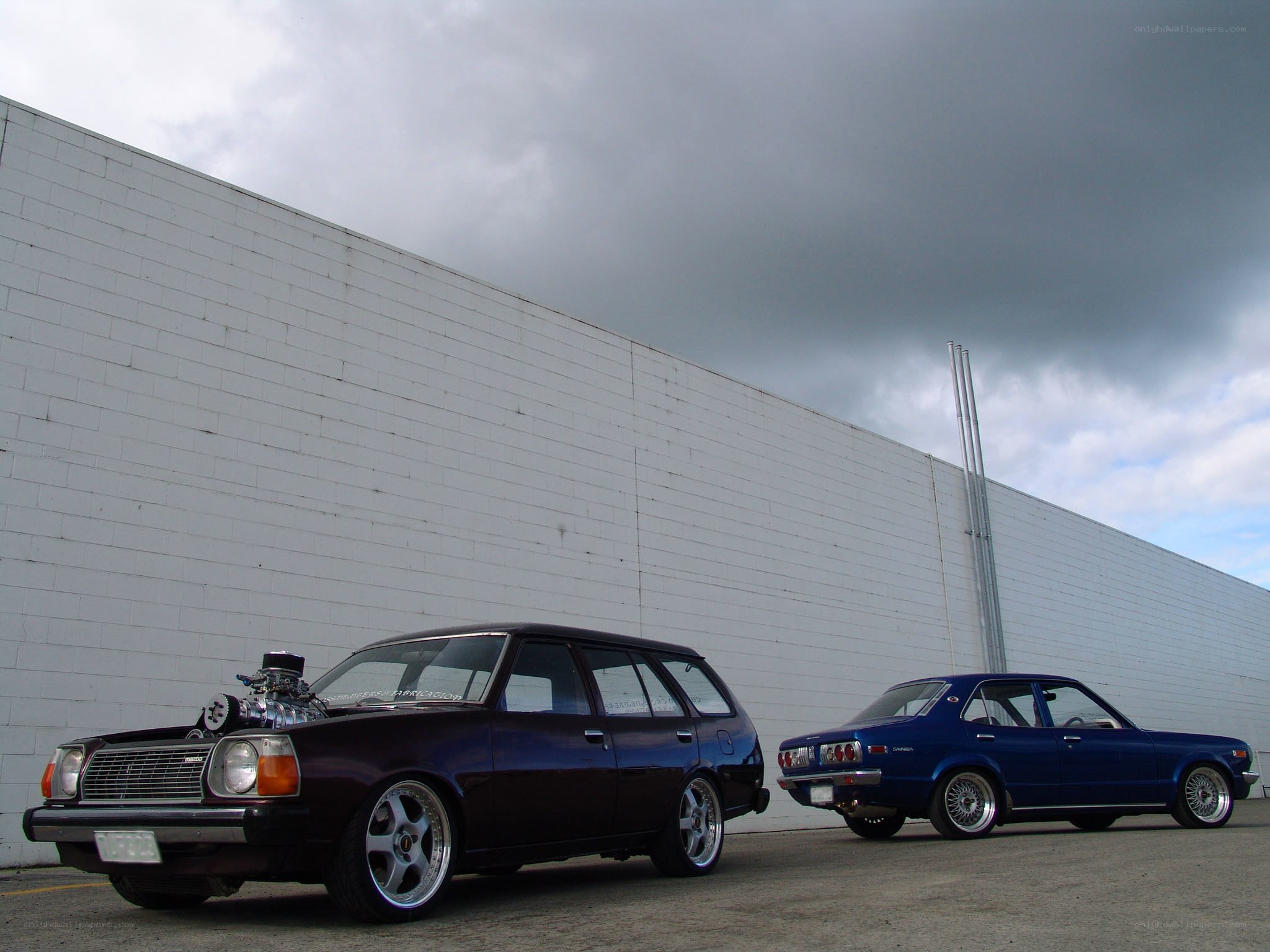 Two classic cars parked outside