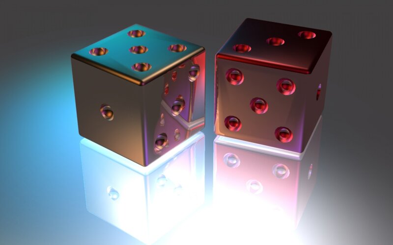 Two colorful dice on reflective surface