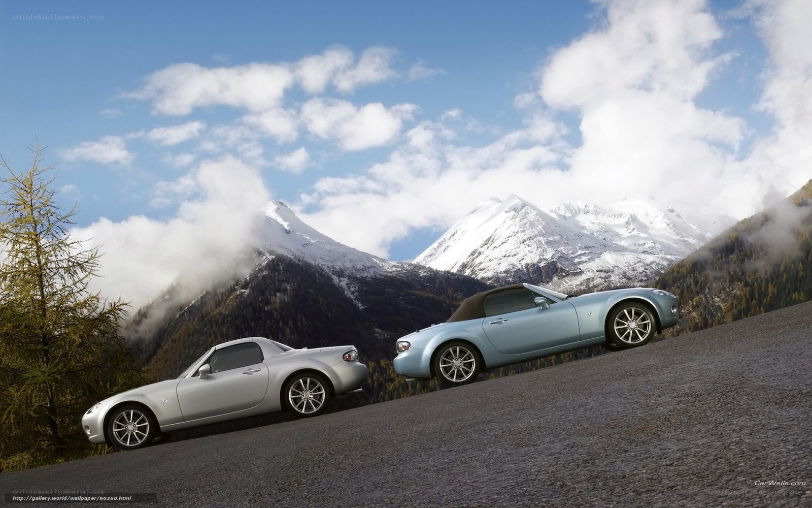 Two convertibles on a mountain road