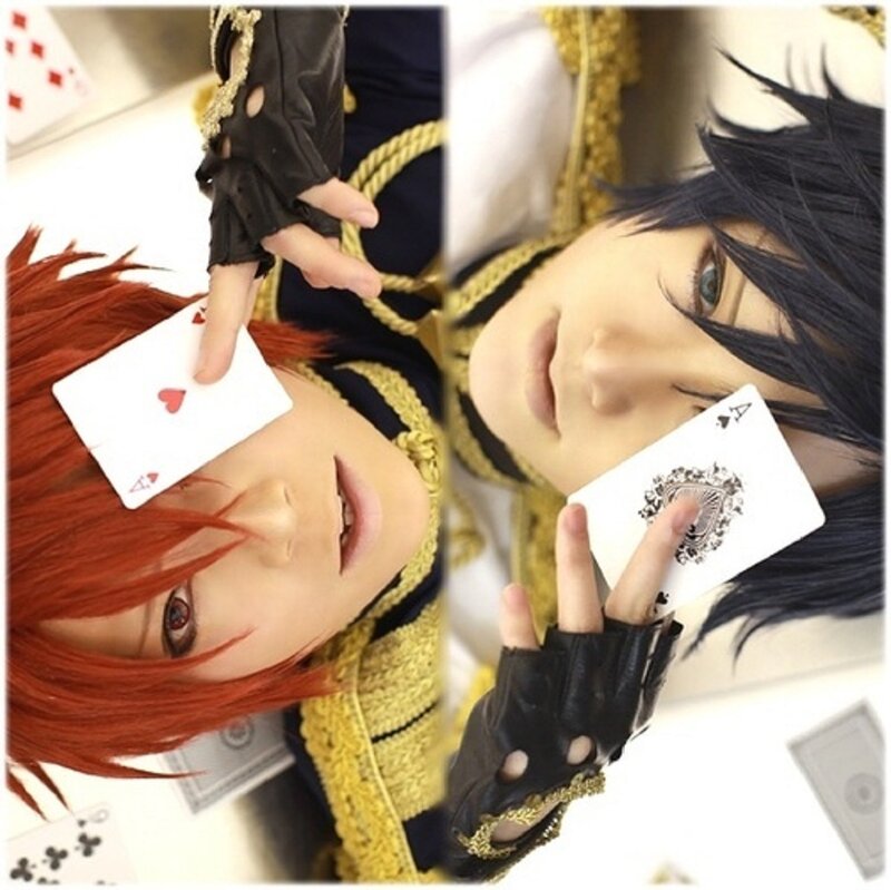 Two Cosplayers Holding Cards