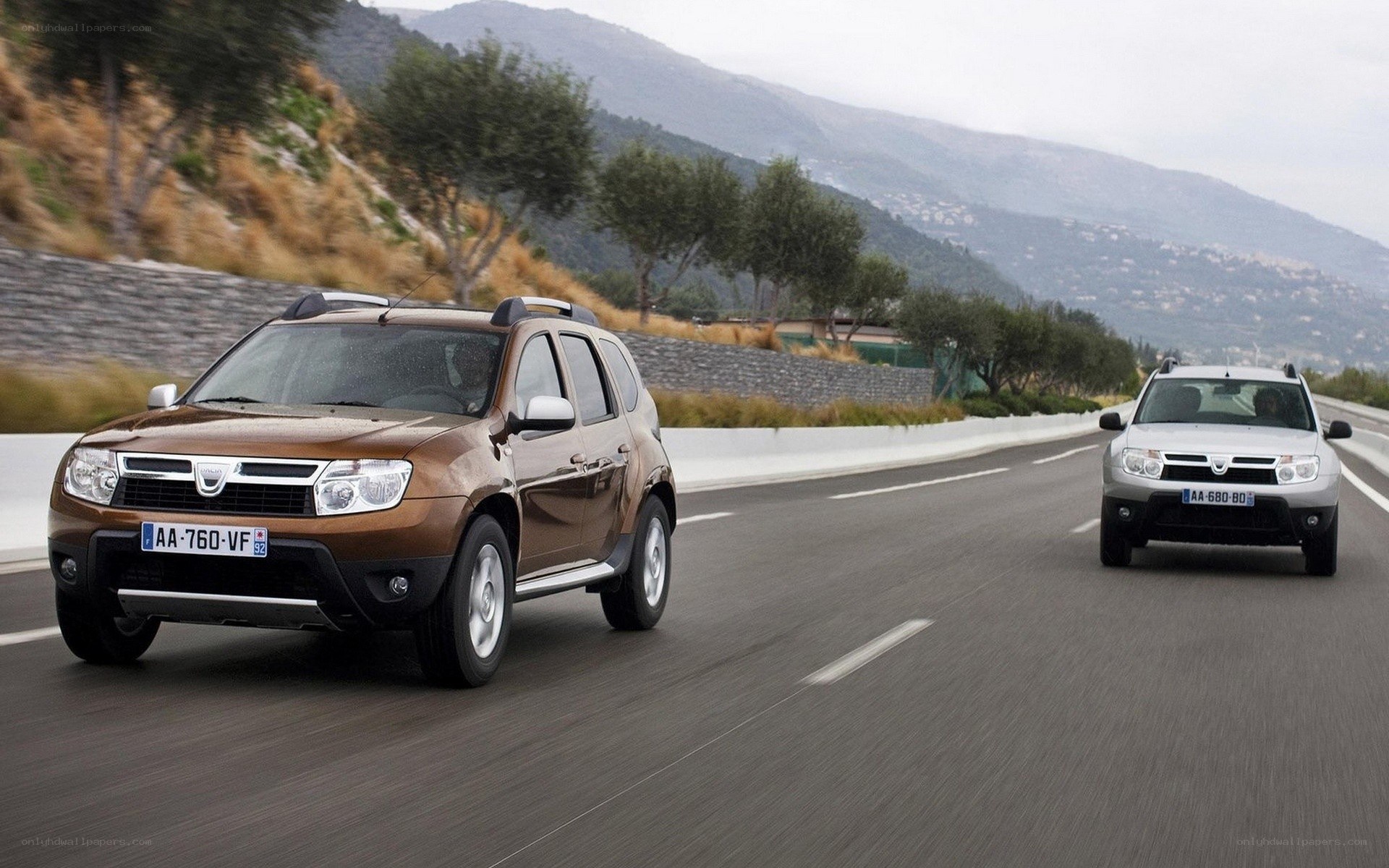 Two Dacia SUVs on a mountain road
