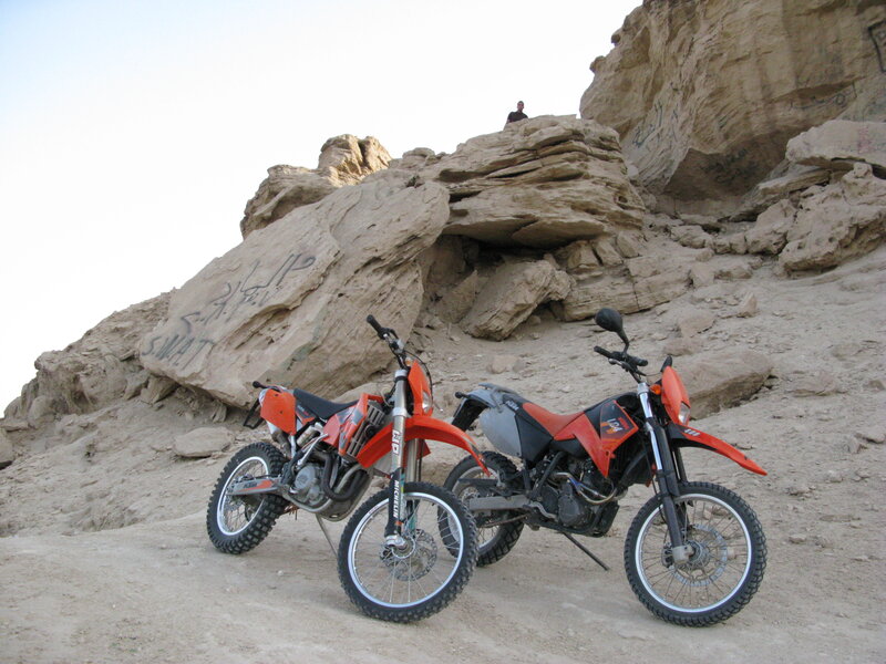 Two dirt bikes on a rocky hillside