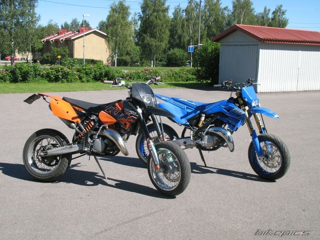 Two dirt bikes parked outside