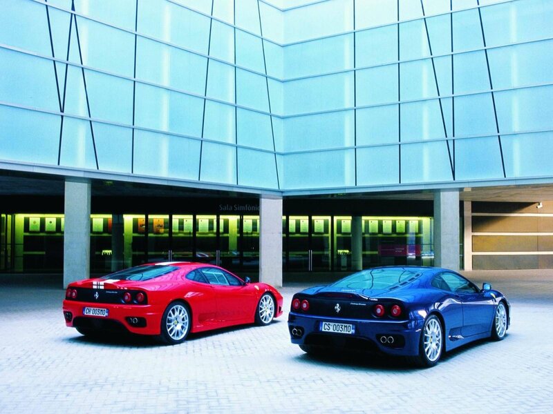 Two Ferraris in front of a modern building