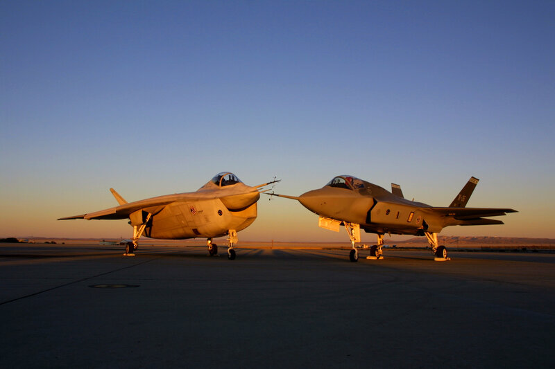 Two fighter jets on tarmac at sunset