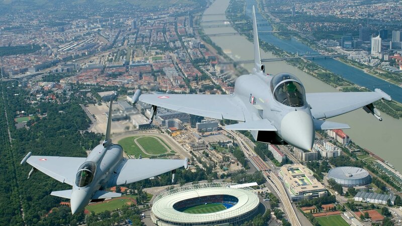 Two fighter jets over a city