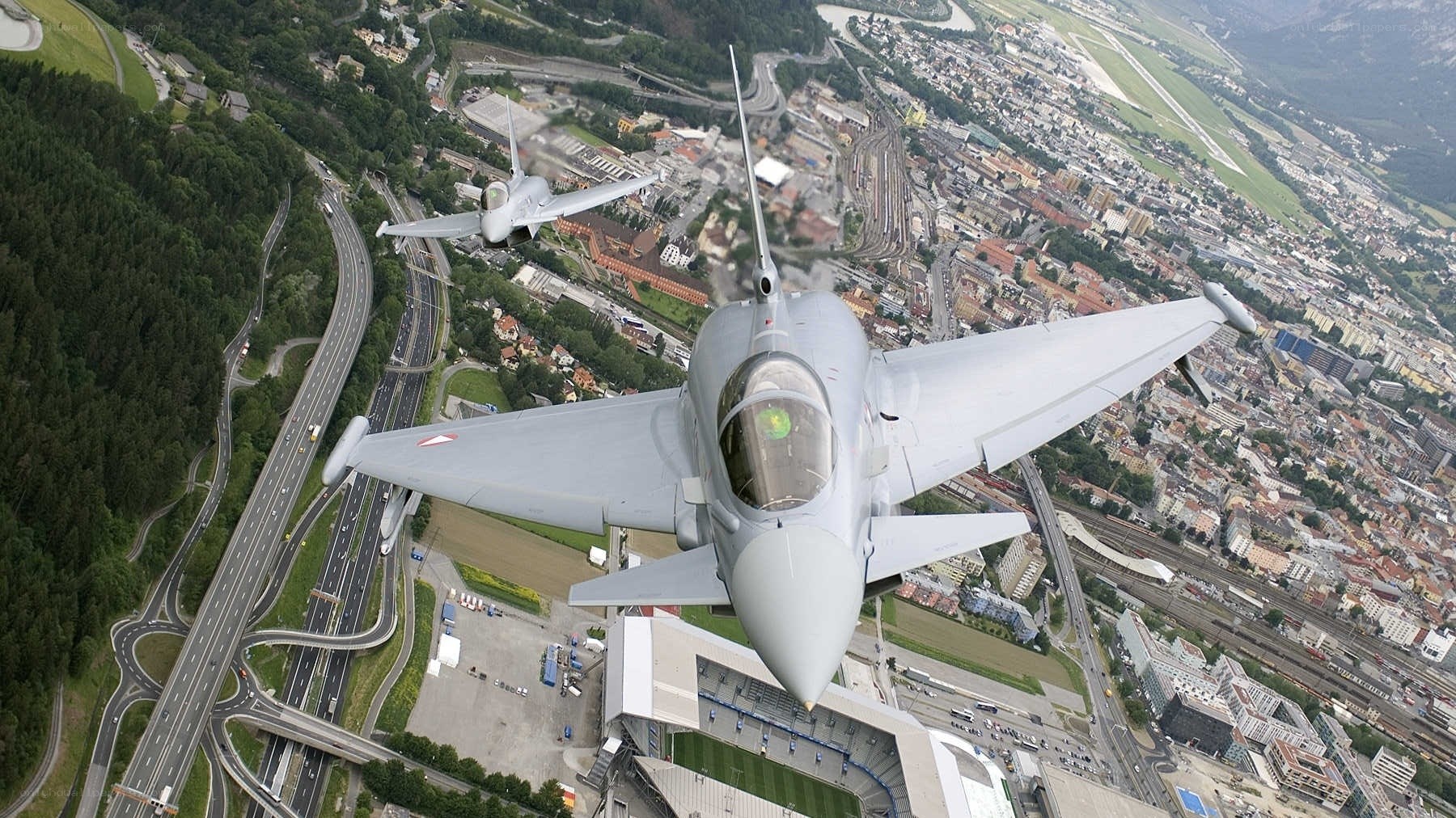 Two fighter jets over a city