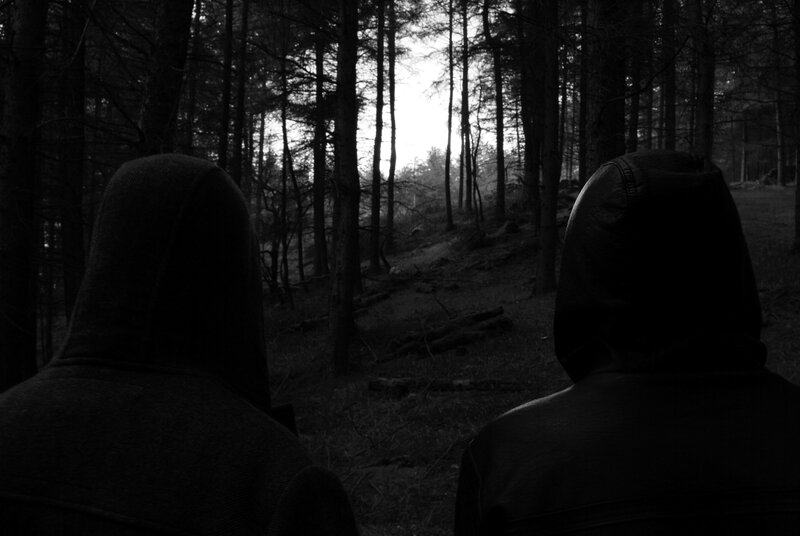 Two figures in a dark forest
