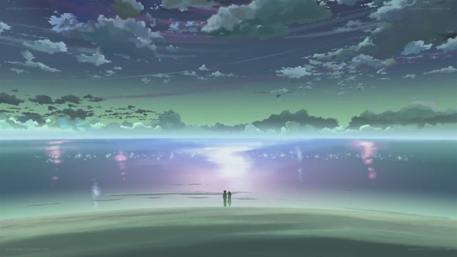 two figures on a beach at dusk