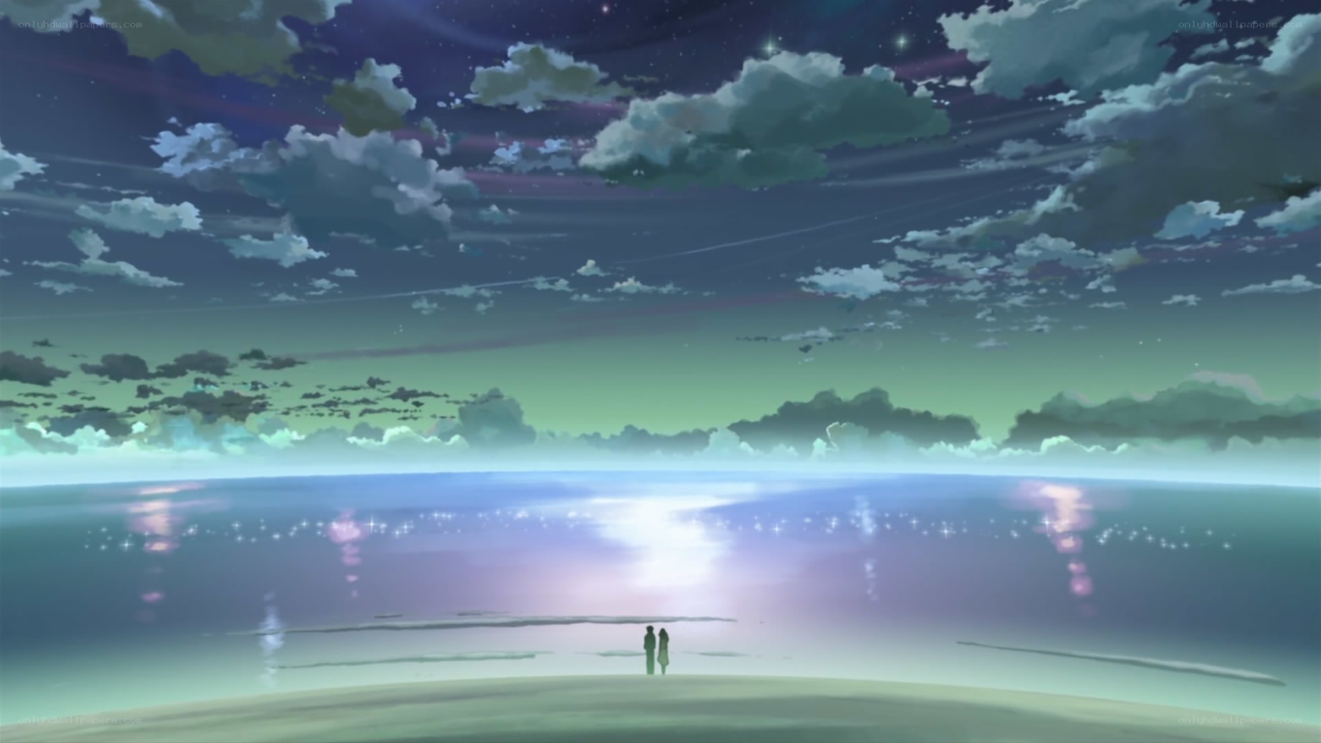 two figures on a beach at night