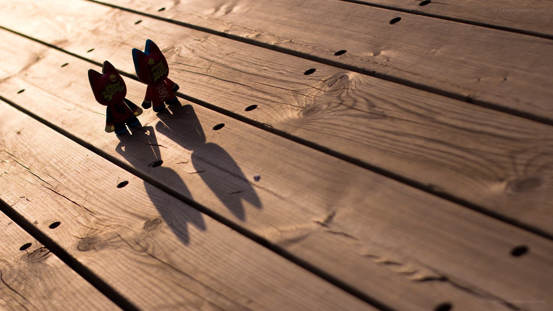 Two figurines on a wooden deck