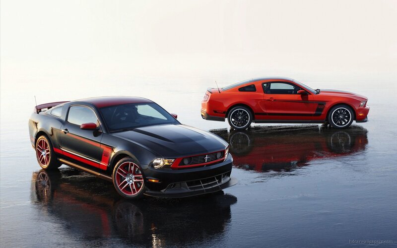 Two Ford Mustangs on wet surface