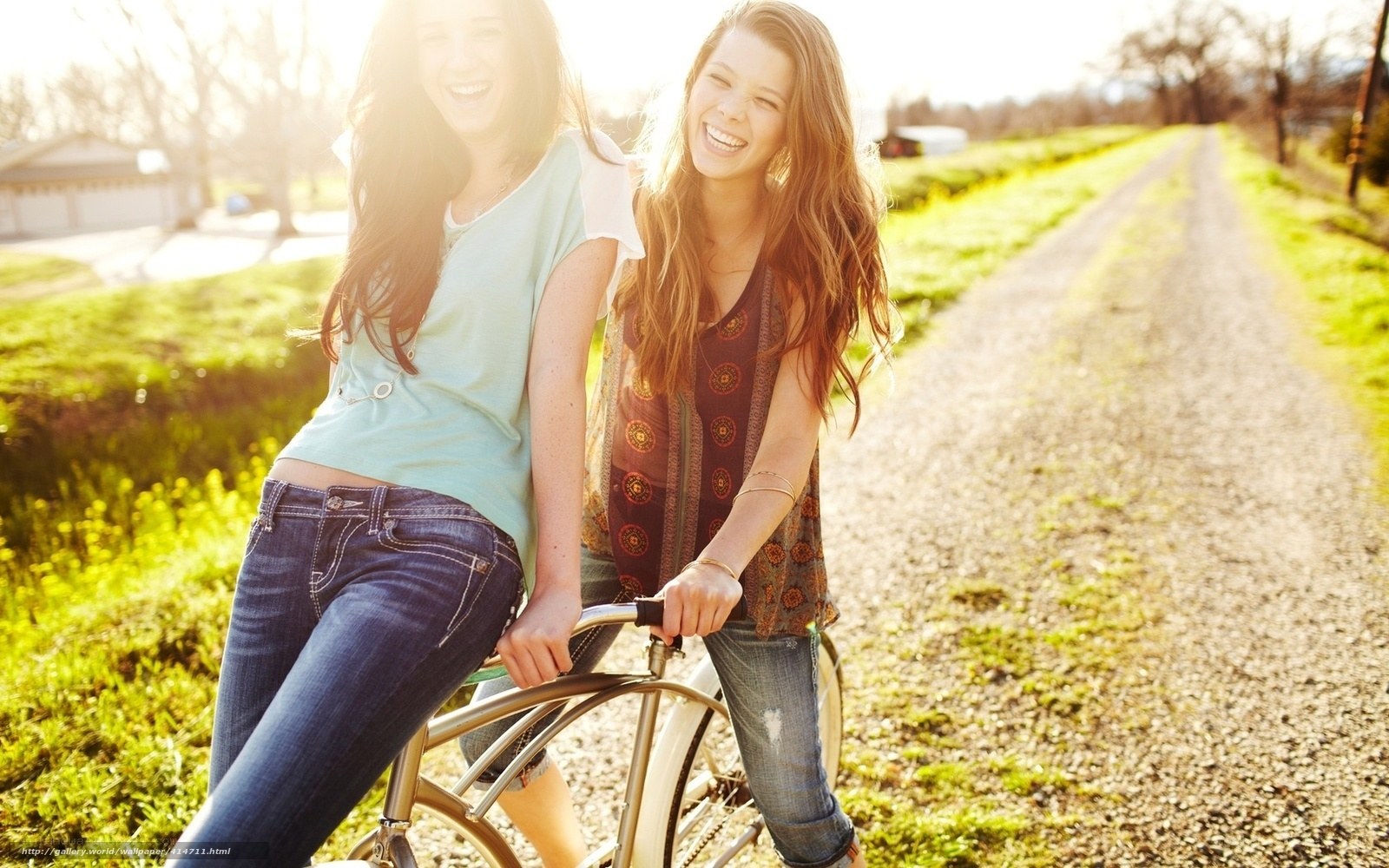 Two friends laughing on a bike