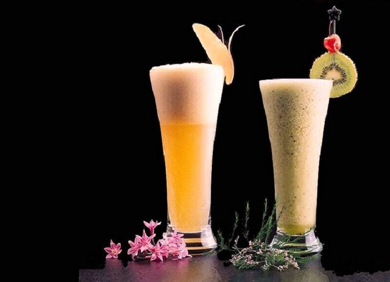 Two fruit drinks with garnishes