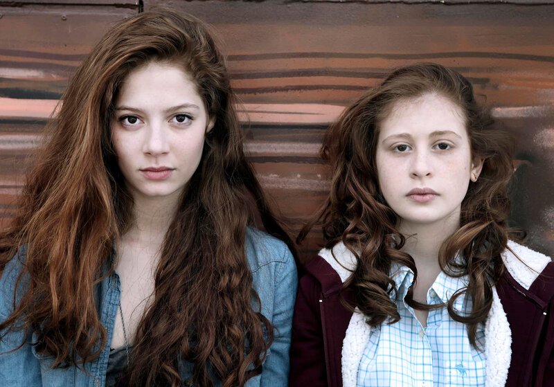 two girls against a wall