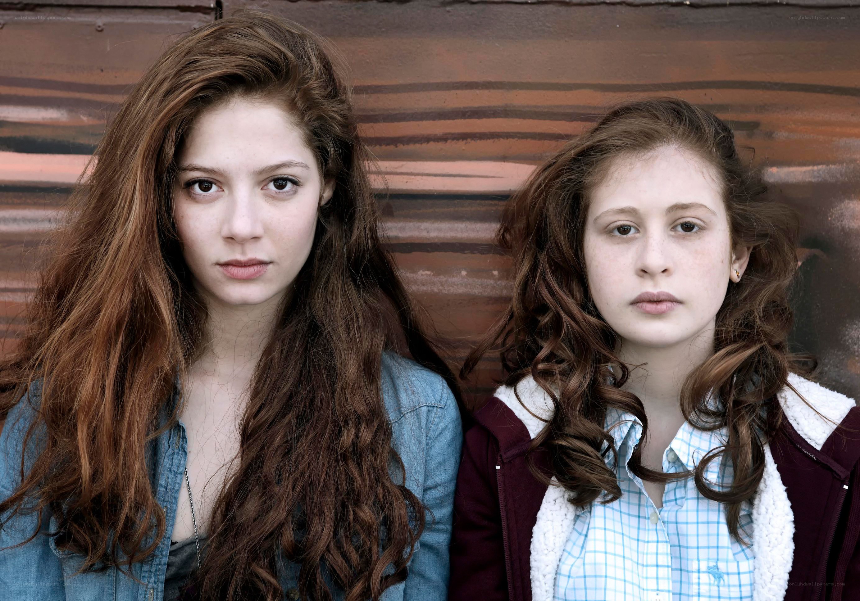 two girls against a wall
