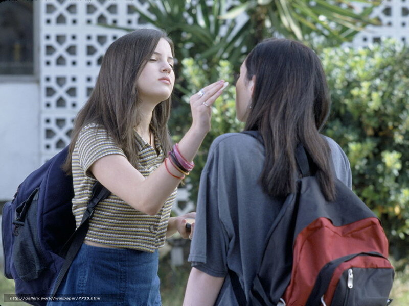 Two girls applying makeup outdoors