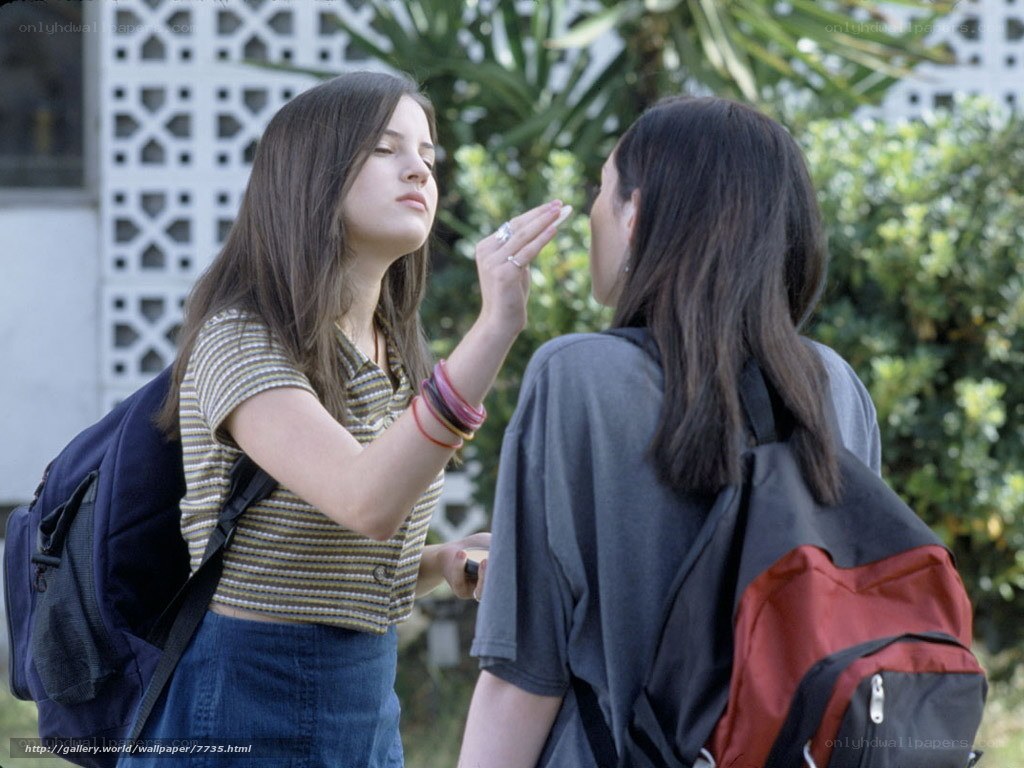 Two girls applying makeup outdoors