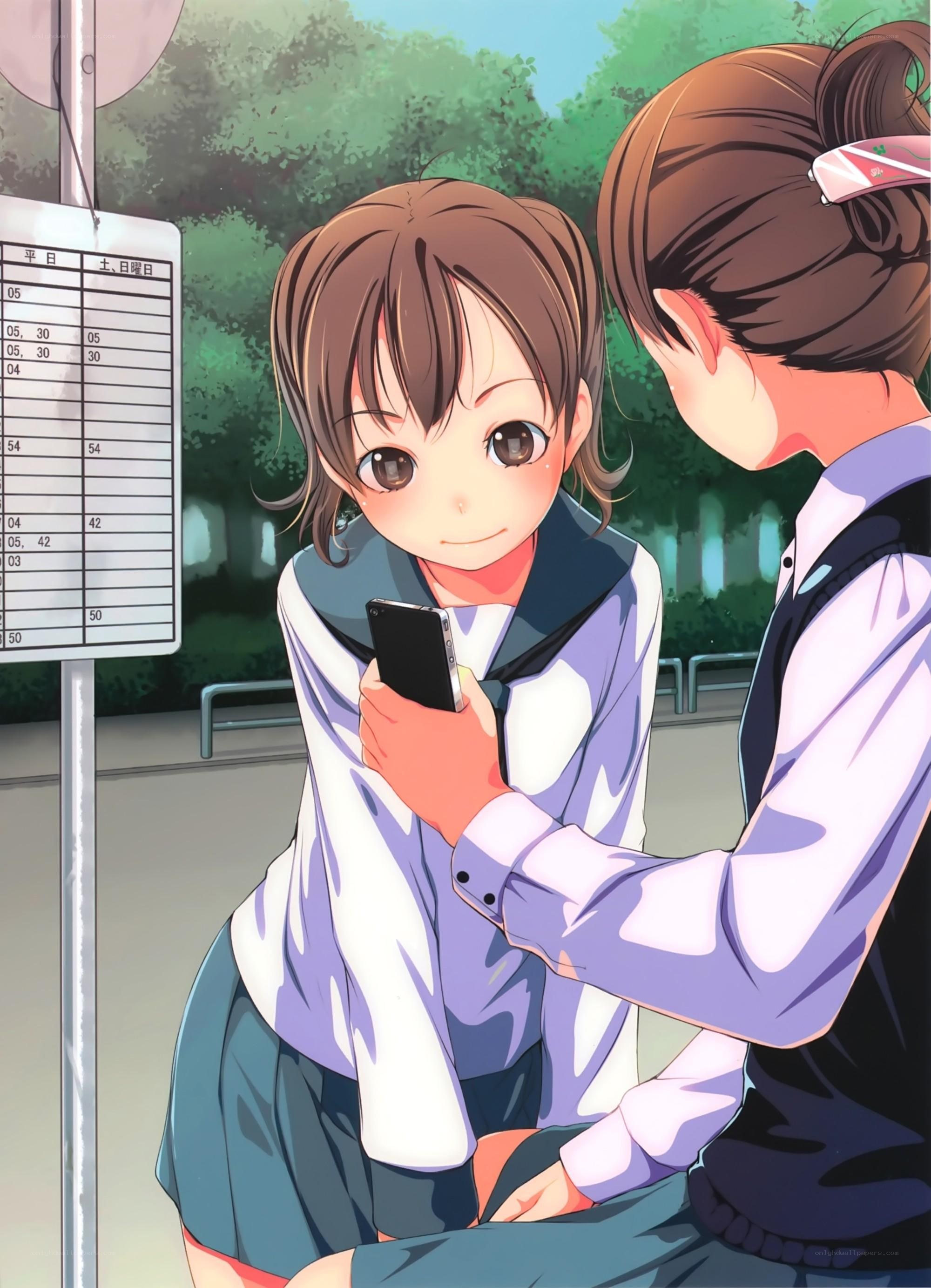 Two girls at a bus stop