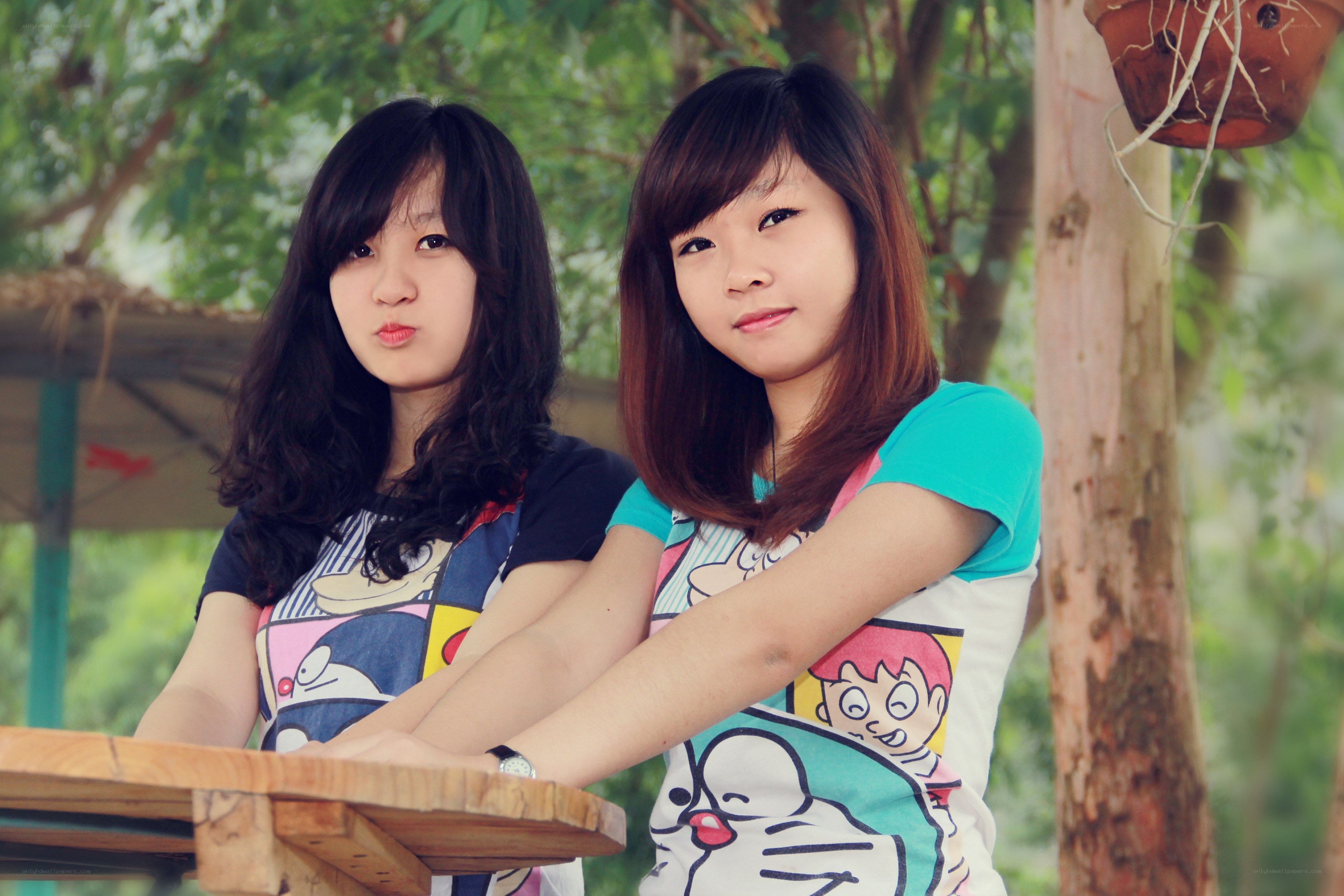 two girls at a table outdoors
