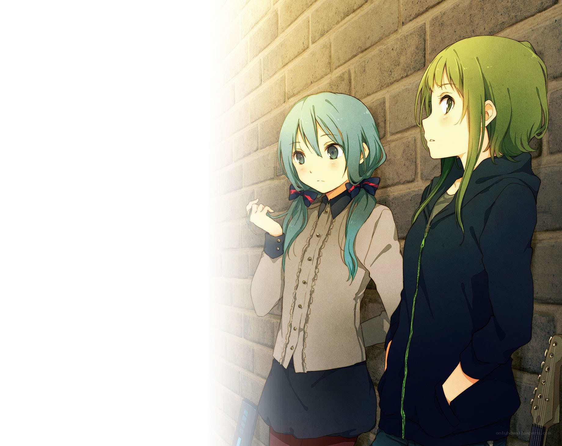 Two girls by a brick wall