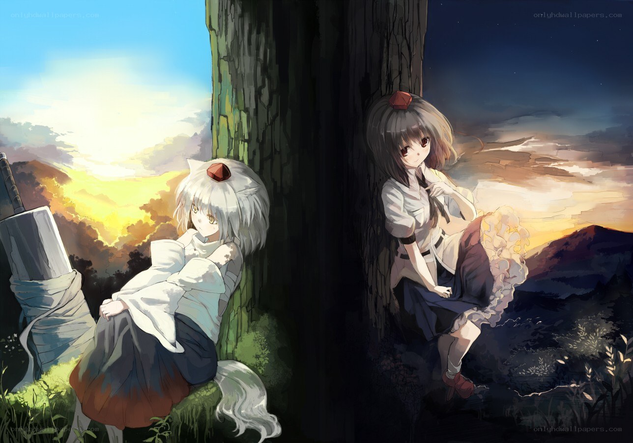 Two girls by a tree at sunset