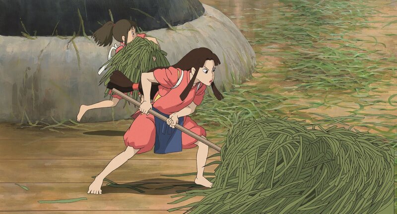 Two girls carrying grass bundles