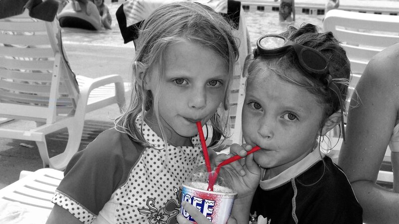 Two Girls Drinking from Cup