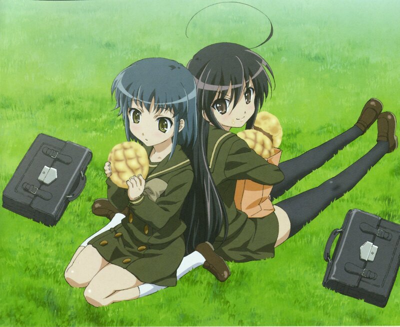 Two girls eating buns on grass