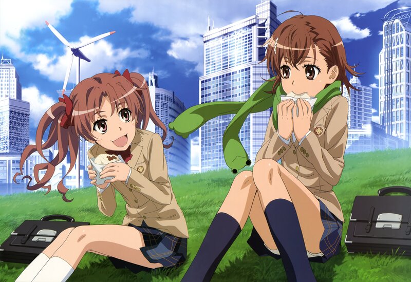 Two girls eating on a grassy field