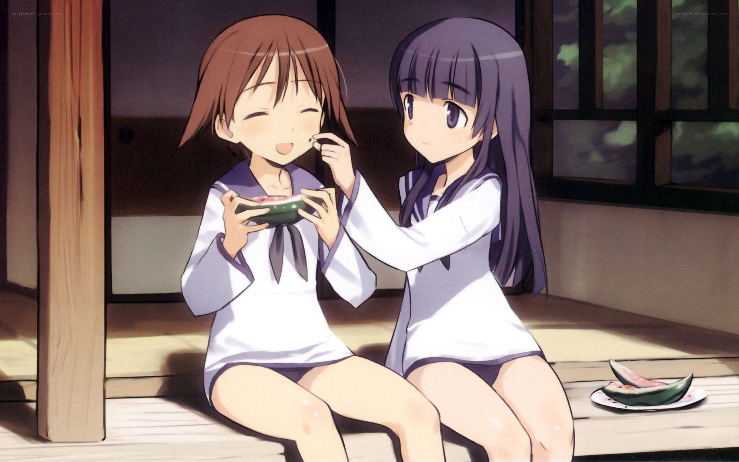 Two girls eating watermelon