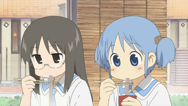 Two girls eating with chopsticks