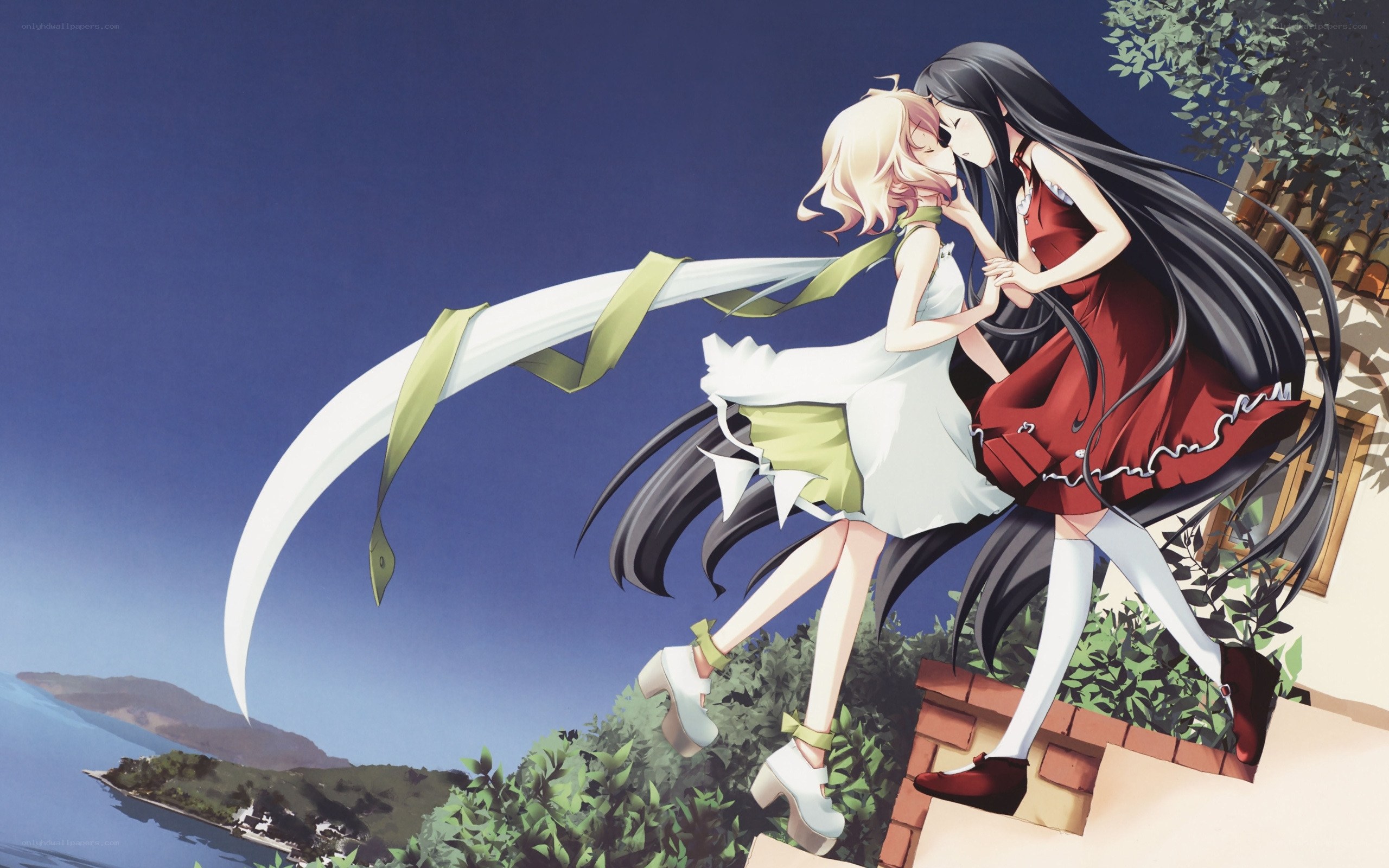 Two girls embracing on a cliff