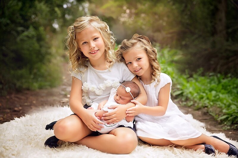 Two Girls Holding Baby