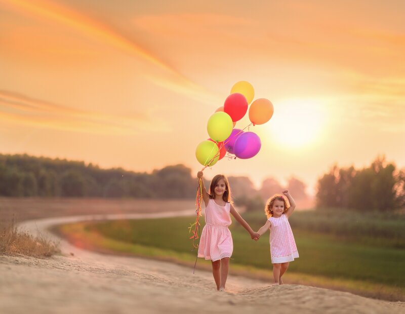 Two Girls Holding Balloons — Orange
