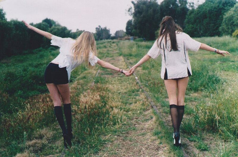 Two girls holding hands in a field
