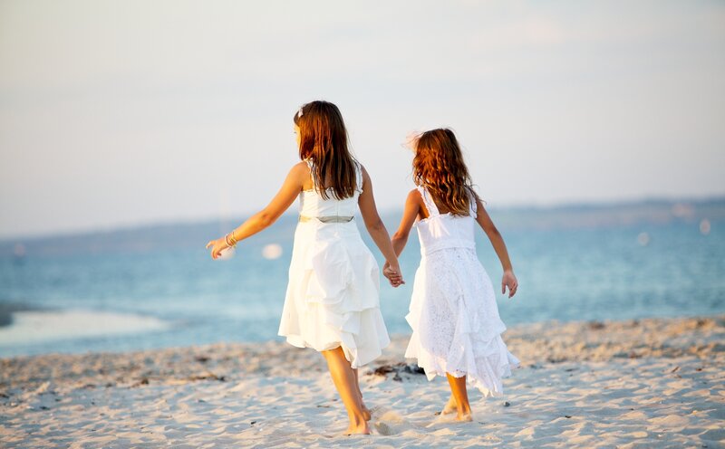 Two Girls Holding Hands — White, Serene, Sunset