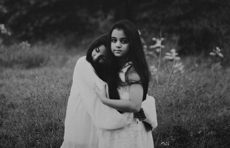 two girls hugging in a field