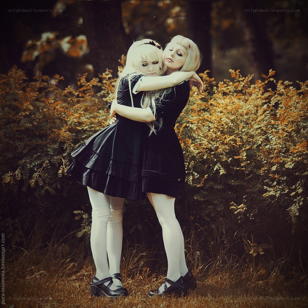Two girls hugging in a forest