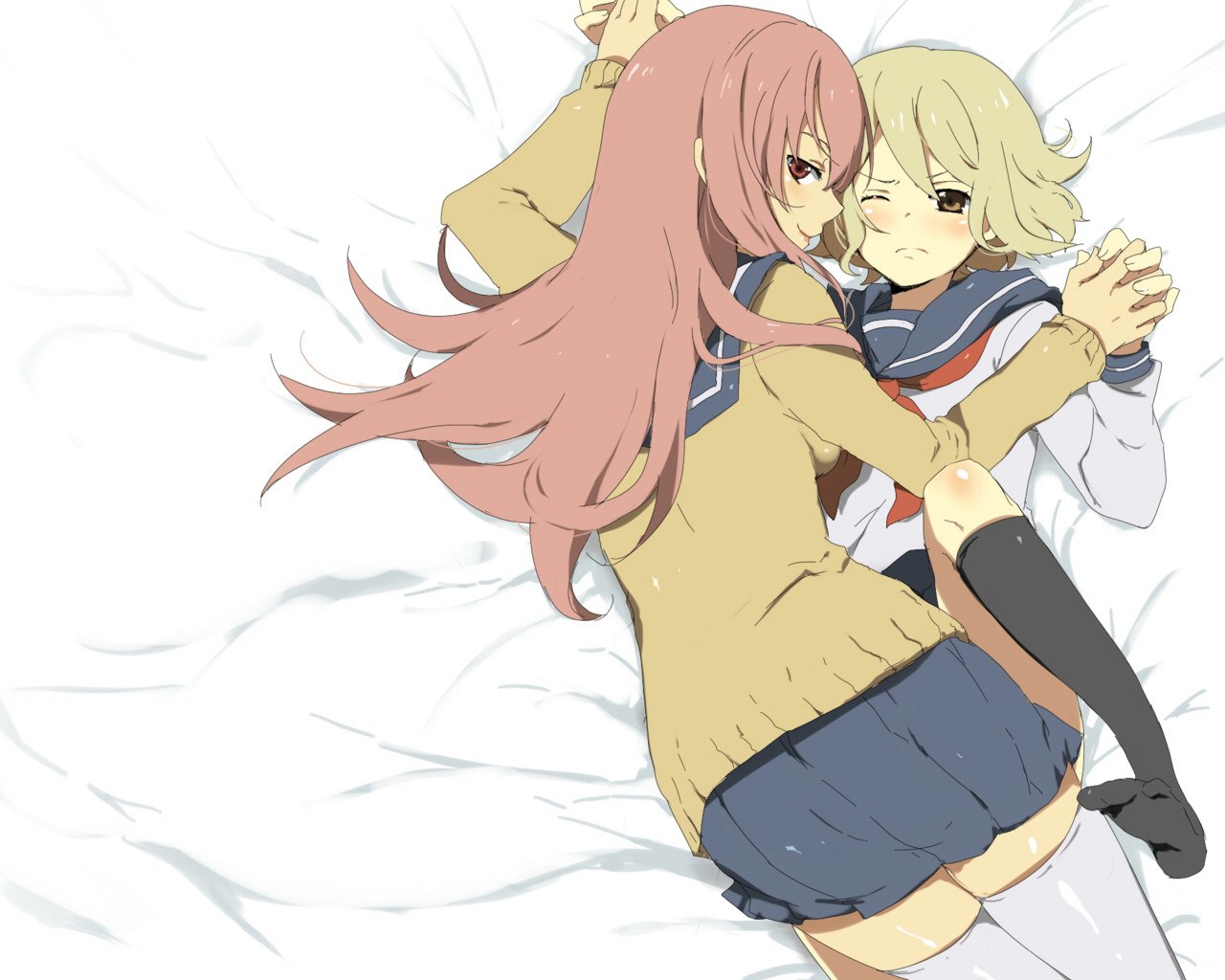 Two girls hugging on a bed