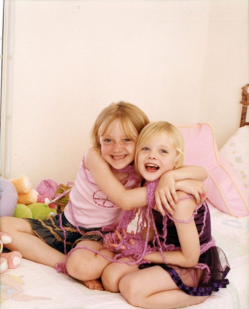 two girls hugging on a bed