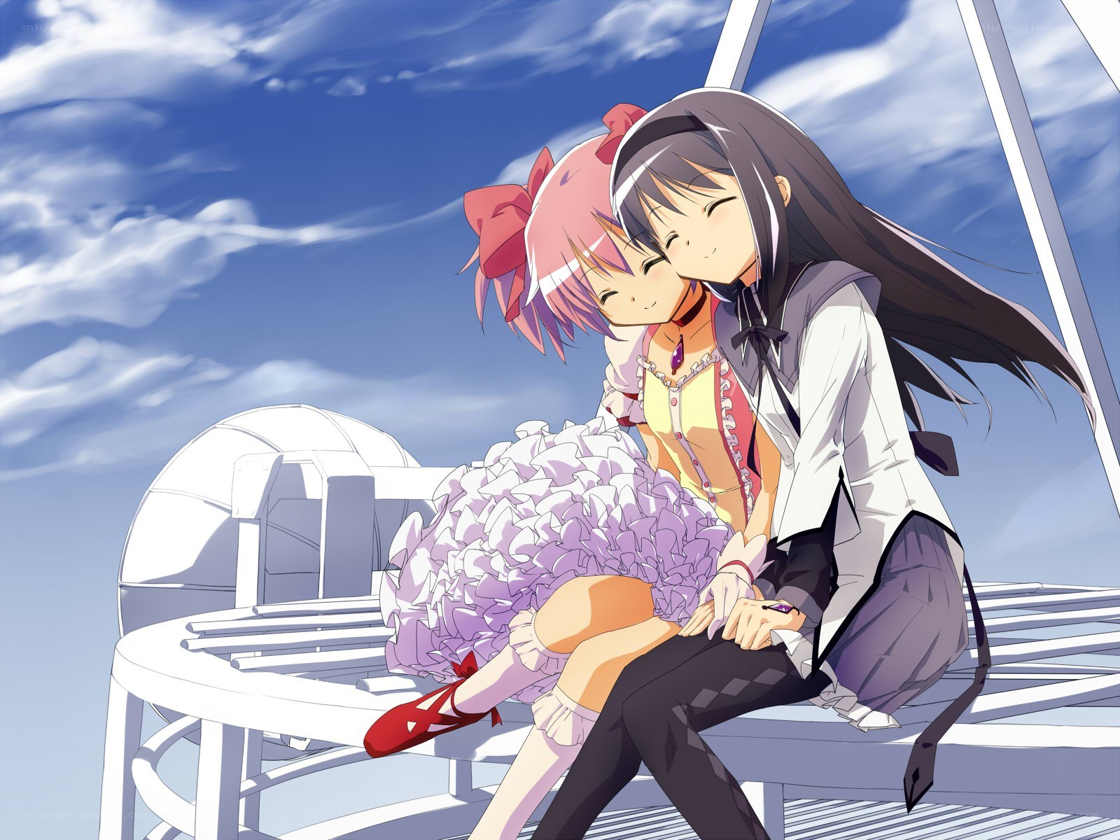 Two girls hugging on a bench