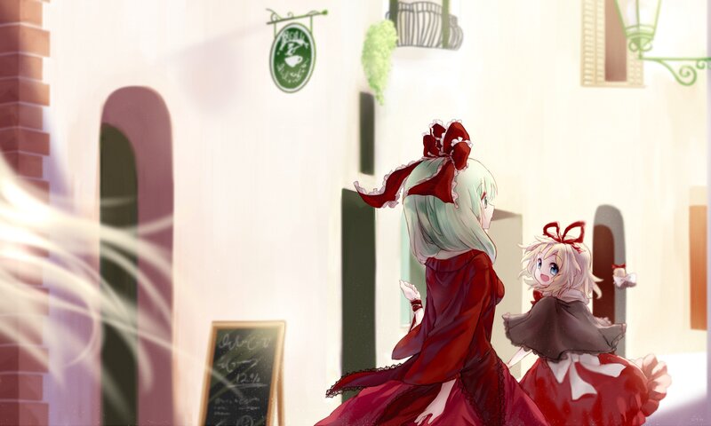 Two girls in red dresses on a street