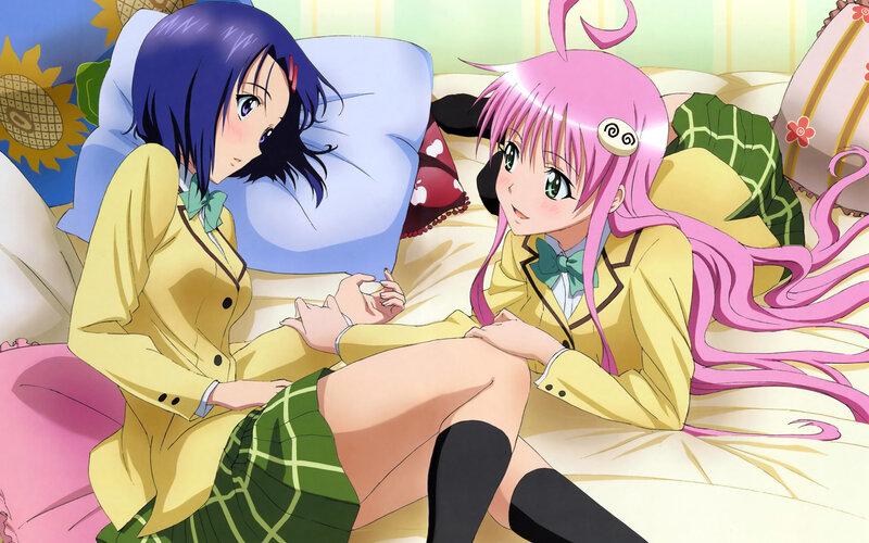 Two girls in school uniforms on a bed