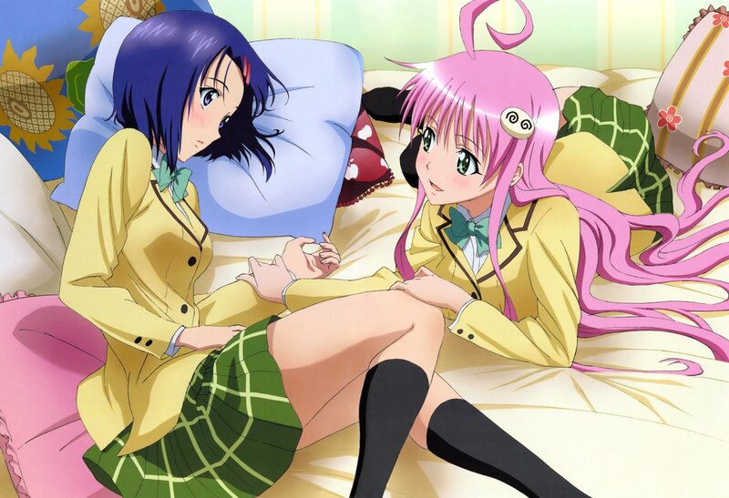 Two girls in school uniforms on a bed
