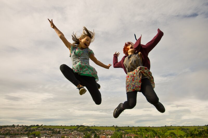 Two girls jumping in joy